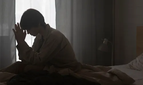 Woman sitting in bed during a frightening sleep paralysis experience