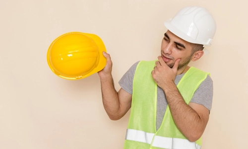 Construction worker holding safety helmets used on modern job sites