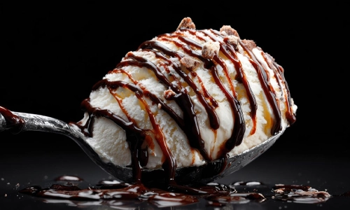Scoop of vanilla ice cream with chocolate syrup and toppings