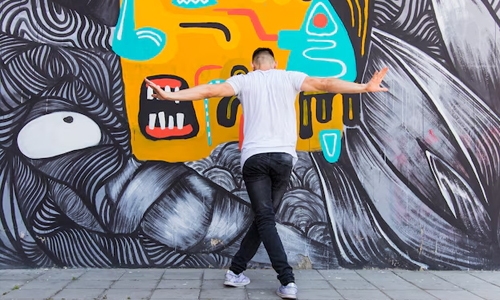 A man in front of graffiti